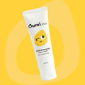 Oumi Kids calm & hydrate face cream tube on a yellow background